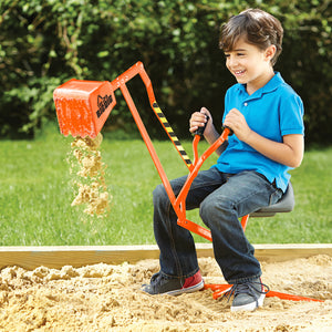 Boy in a sandpit dumping sand on an Orange Special Edition Big Dig